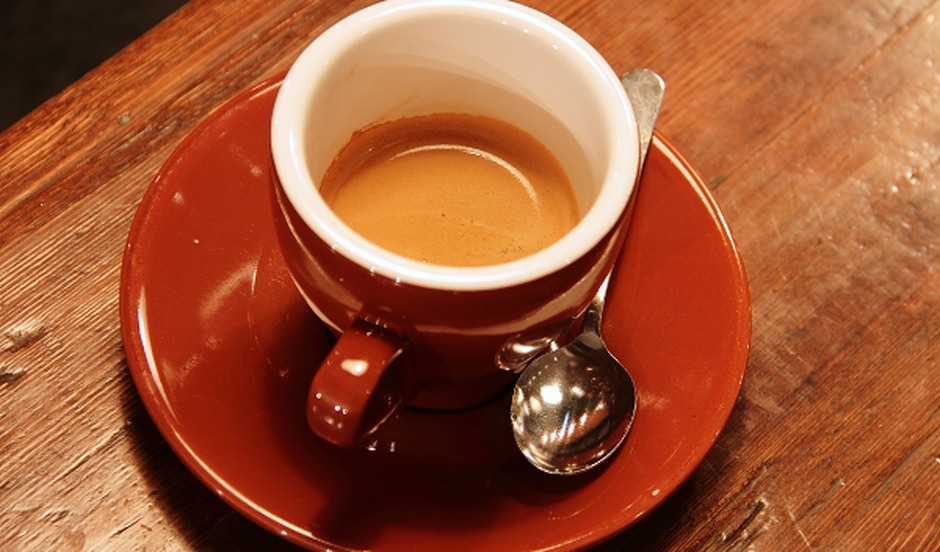 A warm cup of coffee on a wooden table, suggesting an informal conversation and a place to exchange ideas.
