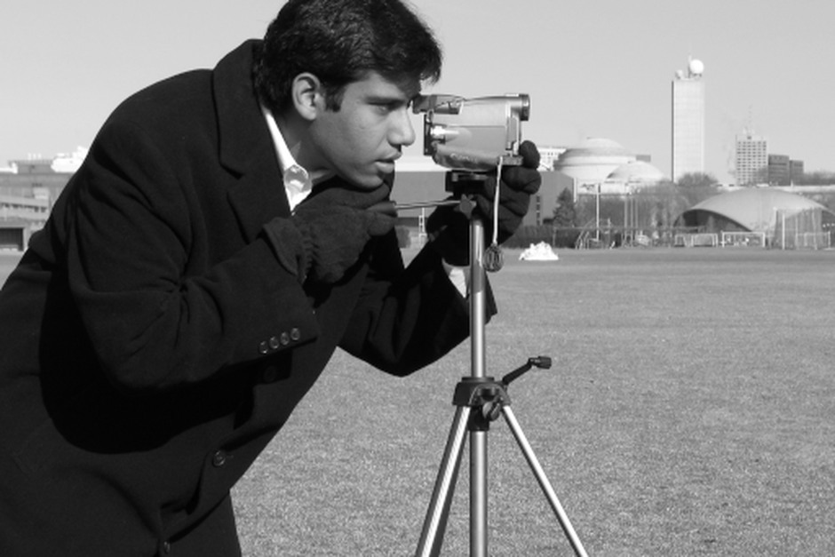 A photographer using a camera on a tripod during an outdoor photo session.