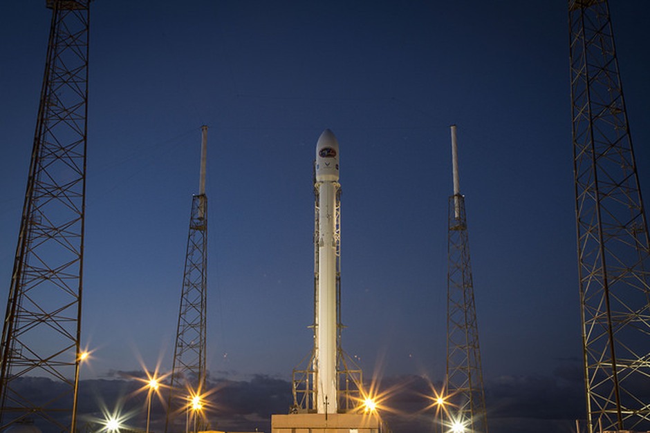 A rocket on its launch pad at dusk, framed by service towers and evening light.